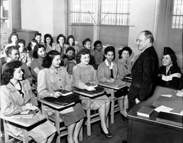 Principal Mortimer C. Ritter addresses an academic class at the Needle Trades High School, New York, in April 6, 1944. Students include Fergel Levine, Jean Cultrera, and Ellen Perino.