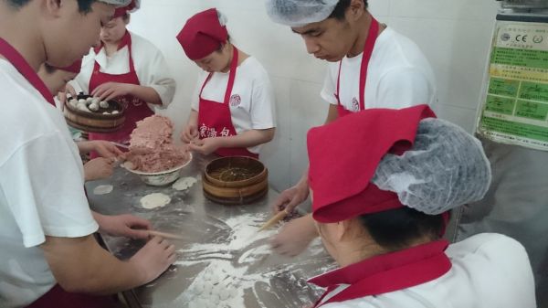 Their entire prepation space. 6 people huddled around a metal benchtop.